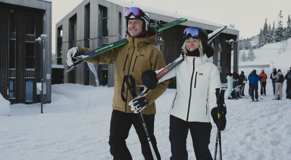 Kjærestepar bærer ski