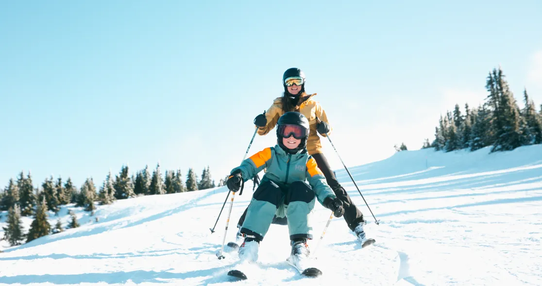 To personer som står på ski i solfylt vinterlandskap.